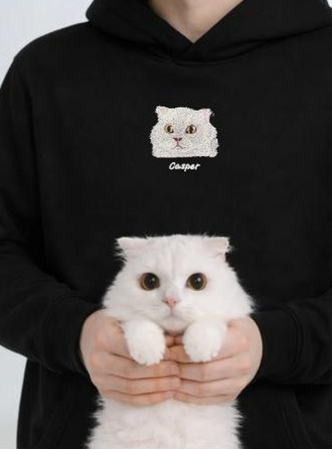 Siyah hoodie'nin göğsüne nakışlanmış kedi portresi; kedi de kucakta